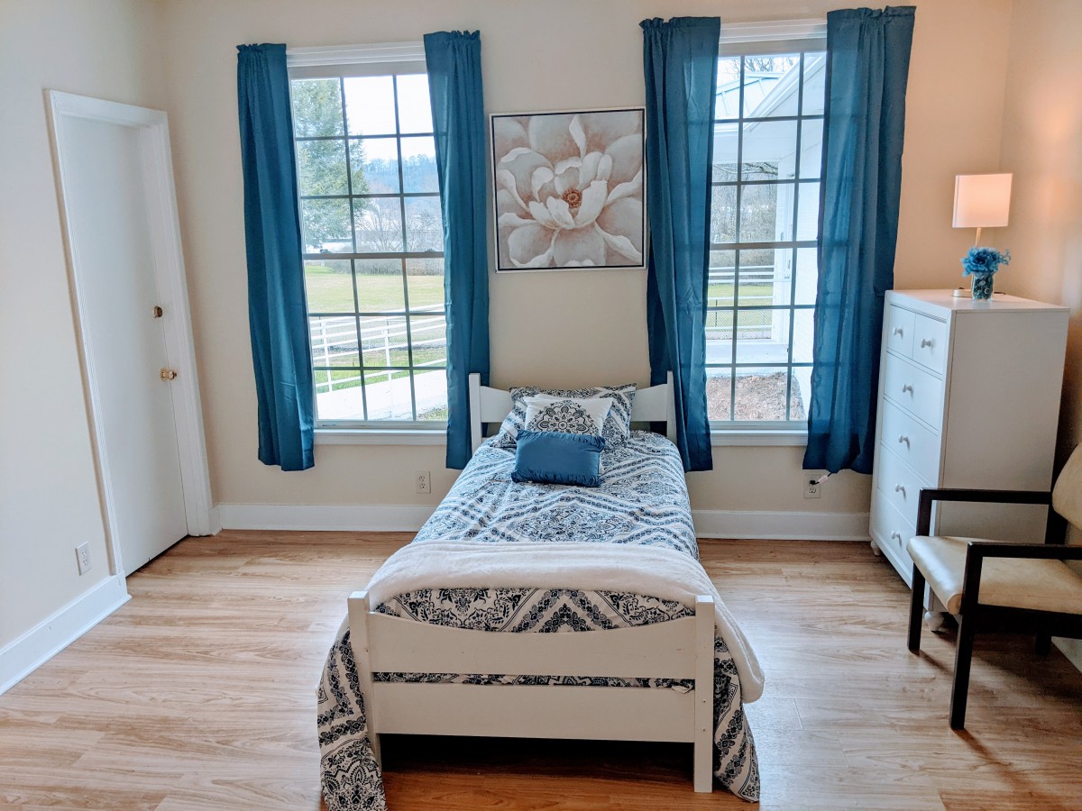 A cozy bedroom with a single bed and blue accents.