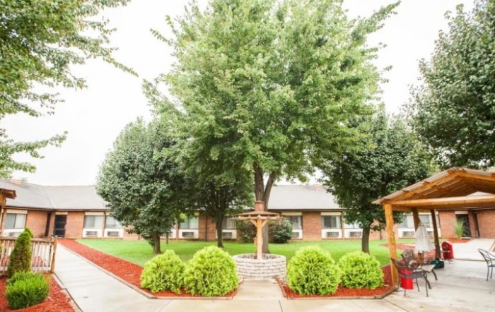 A serene garden with lush trees and neatly trimmed bushes.