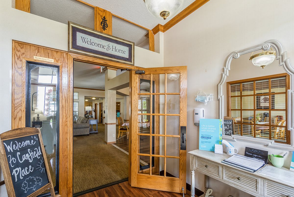 A welcoming entrance to a home with wooden doors and decorative furnishings.