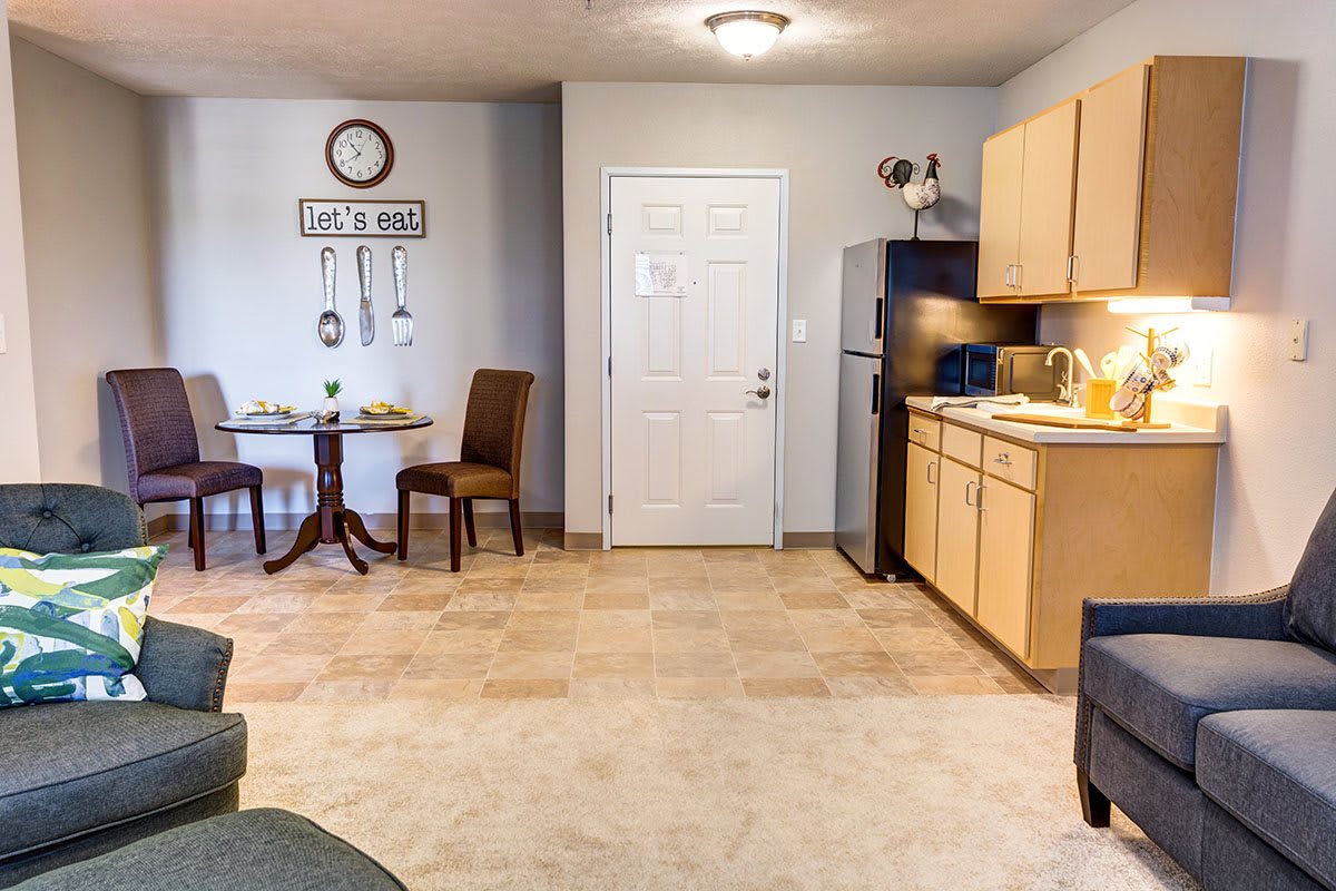 A compact kitchen and dining area with a table, chairs, and basic appliances.