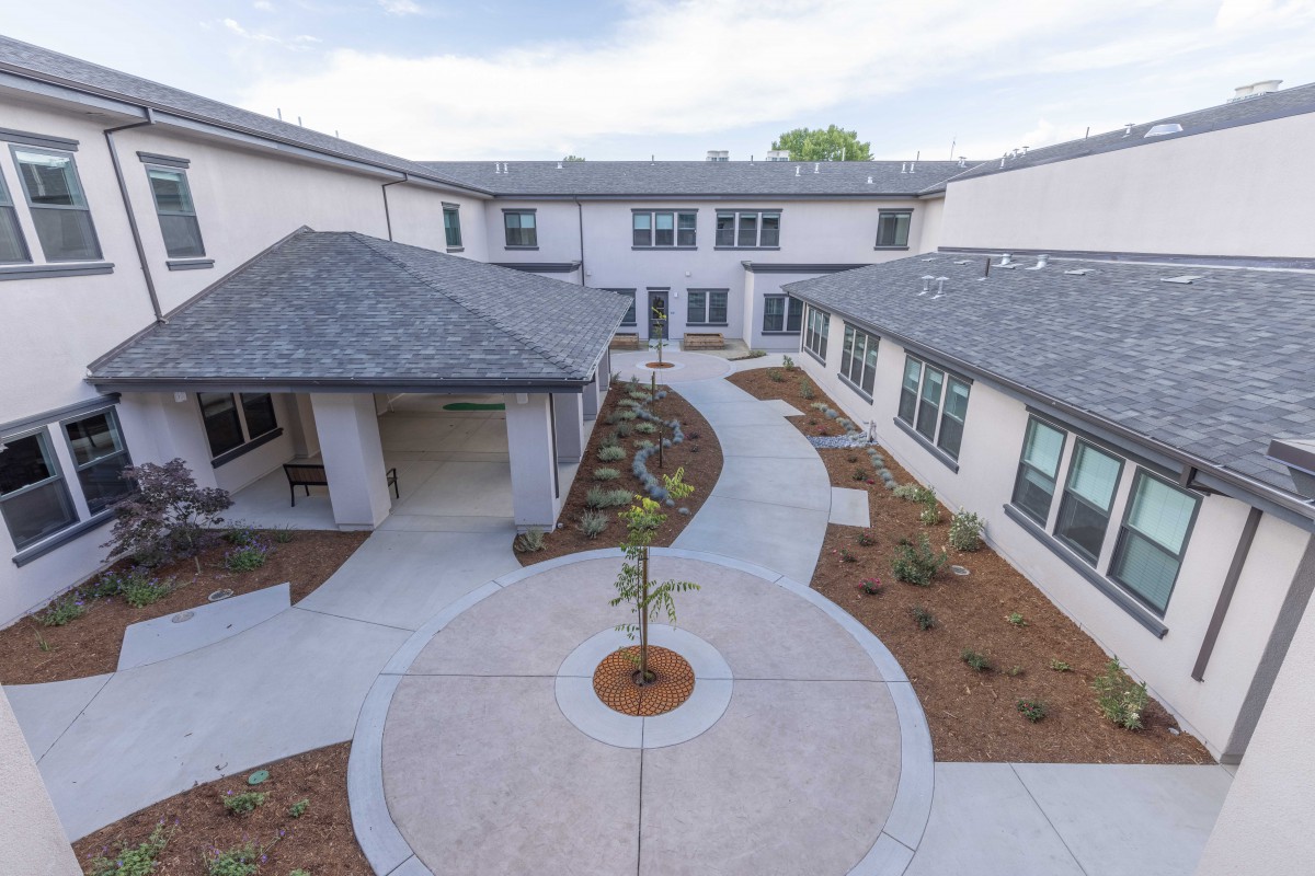 A modern building with a landscaped courtyard and circular pathway.