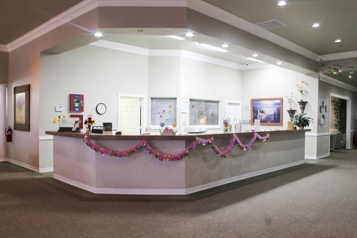 A decorated reception area with a front desk and festive garlands.
