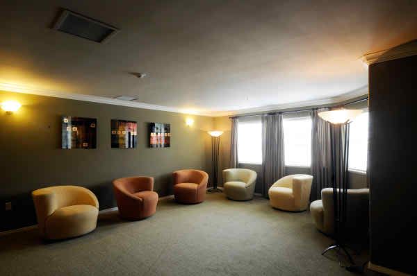 A cozy lounge area with upholstered chairs and subtle lighting.