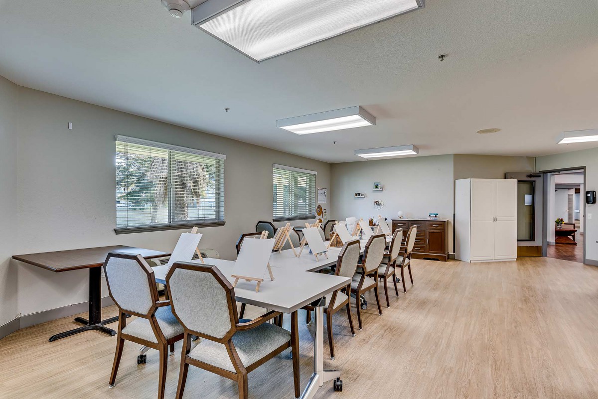 A well-lit conference room with tables and chairs arranged for a meeting.