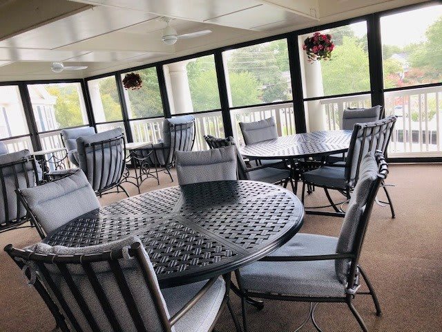 A covered patio with cushioned tables and chairs, perfect for outdoor relaxation.