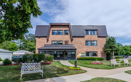 A charming residential building featuring modern architecture, set against a landscaped garden.