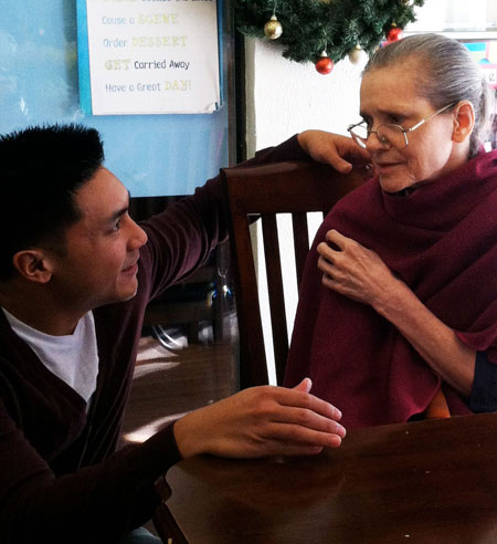 A young man and an elderly woman engaged in a thoughtful conversation.
