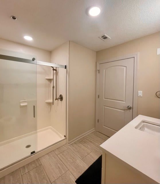 A modern bathroom with a glass shower enclosure and sleek sink.