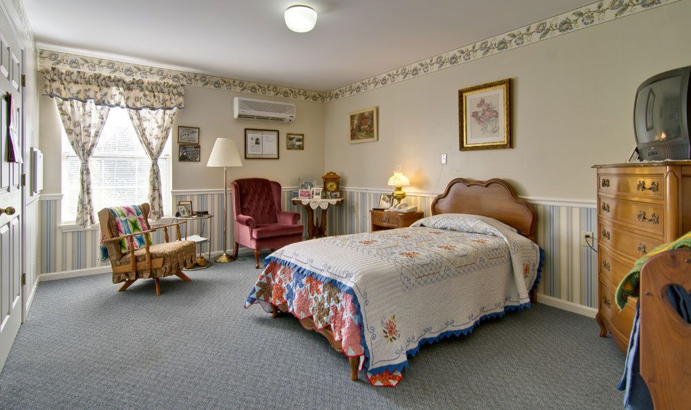 A cozy, vintage-style bedroom with a single bed, armchair, and decorative elements.
