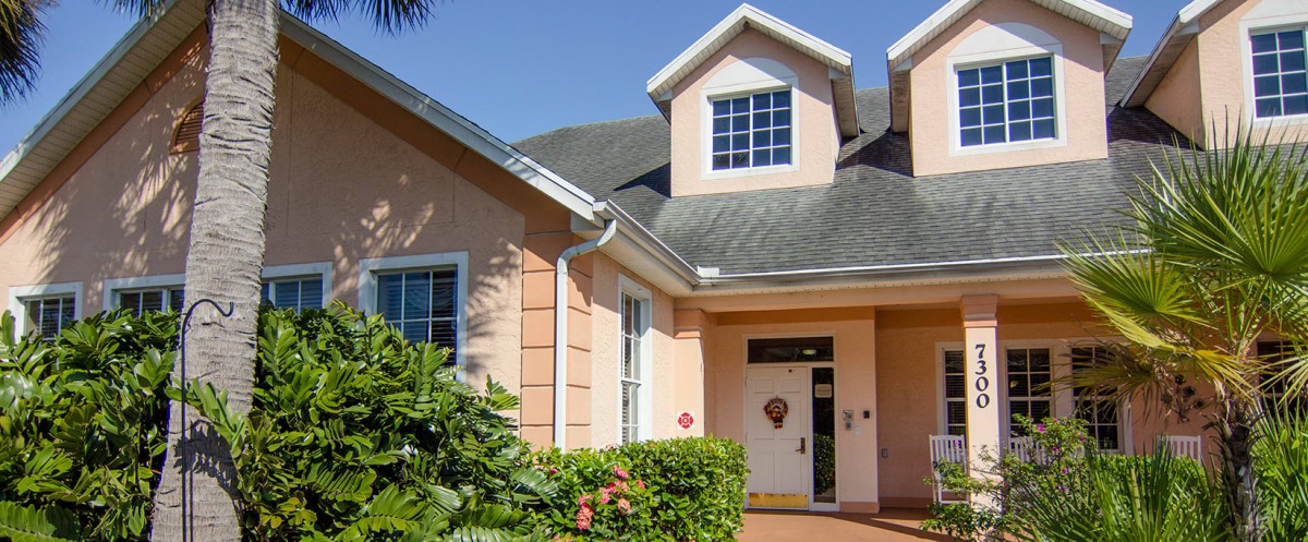 The exterior of a residential house with a front entrance and large windows.