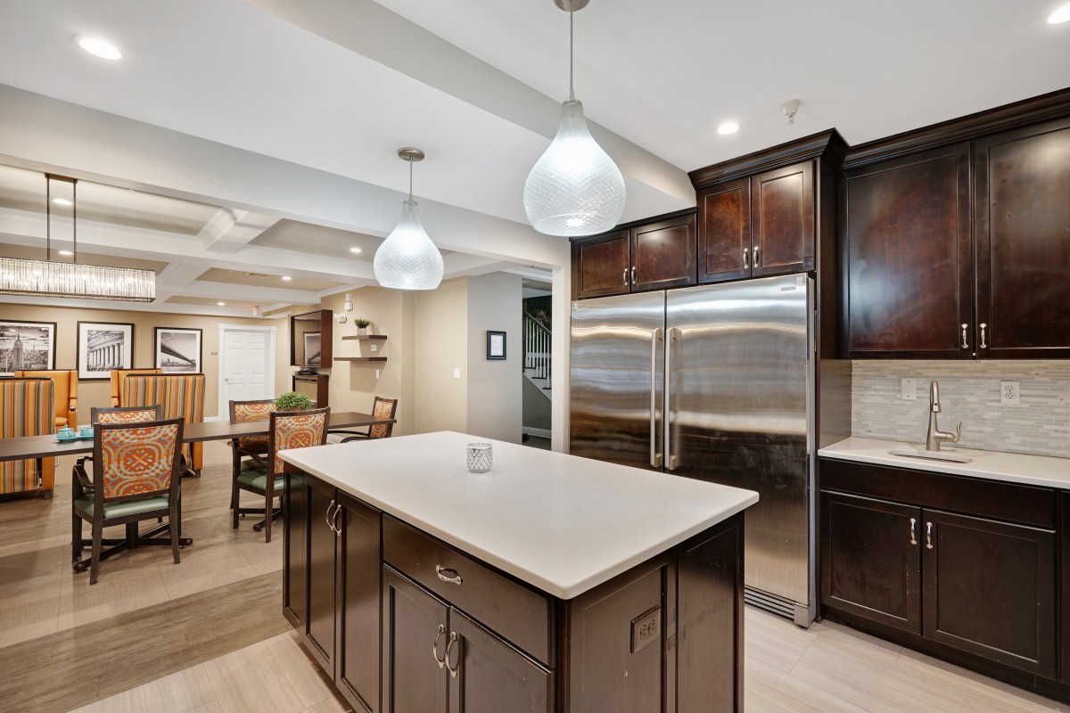 A modern kitchen featuring a central island with pendant lighting and stainless steel appliances.