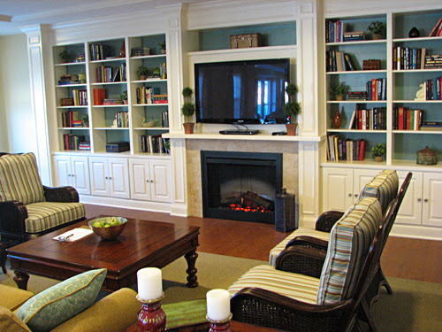 A cozy living room featuring a fireplace, built-in shelves, and comfortable seating arrangements.