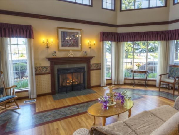 A spacious living room featuring a fireplace and large windows letting in natural light.