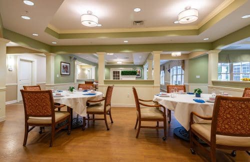 A well-lit dining room with neatly arranged tables and chairs, featuring a cozy and inviting interior.