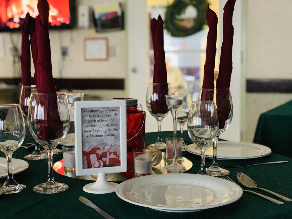 A festive table setting with elegant wine glasses and red napkin decorations, perfect for a holiday celebration.