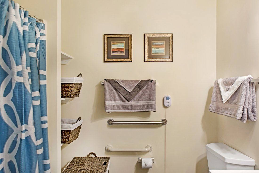 A well-organized bathroom featuring towels, wall art, and storage baskets.