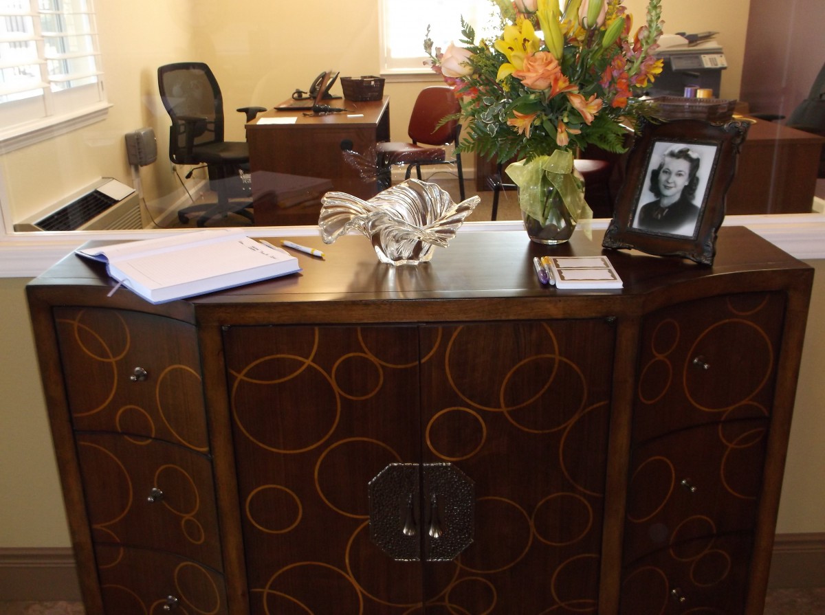 An office desk with flowers, a photograph, and various office items.