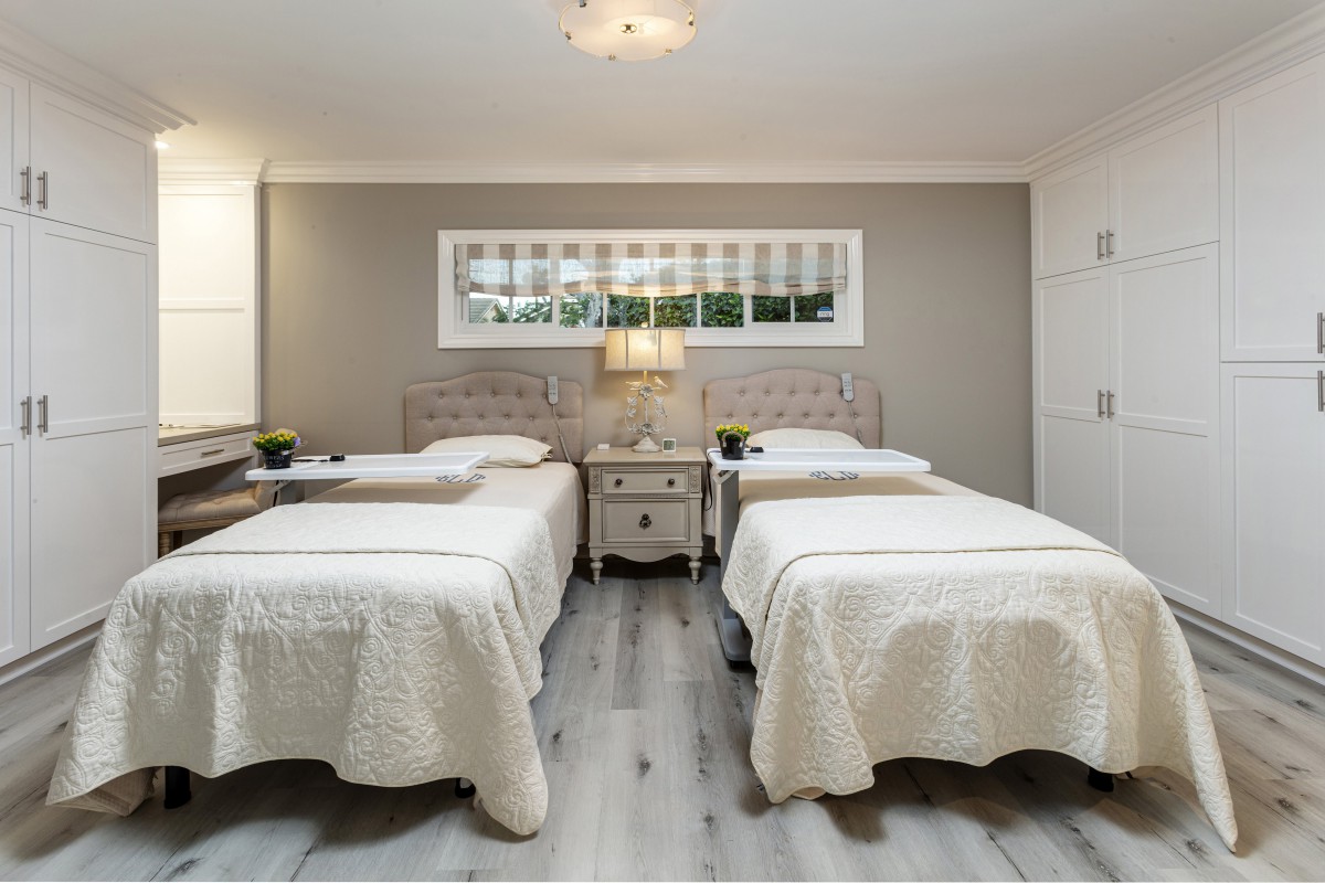 A modern bedroom featuring twin beds with neutral color tones and elegant decor.