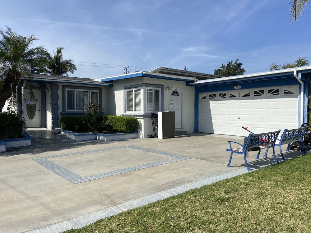 A suburban house with a driveway and garage, featuring a front lawn.