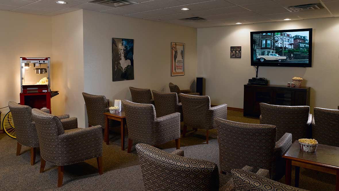 A waiting area with multiple chairs and a television on the wall.