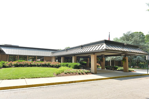 A view of a modern commercial building with a landscaped entrance.