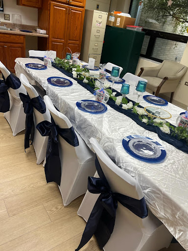 Beautifully arranged dining table set for a formal event with navy blue and silver accents.