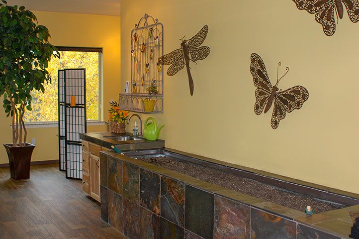 A cozy interior featuring butterfly and dragonfly wall art against warm yellow walls, complemented by a rustic kitchen counter.