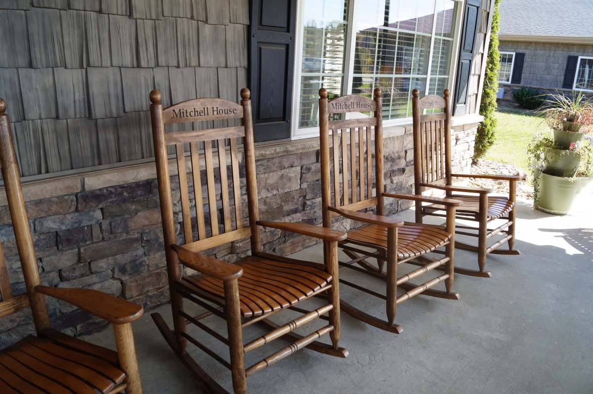 Wooden rocking chairs lined up on a porch.