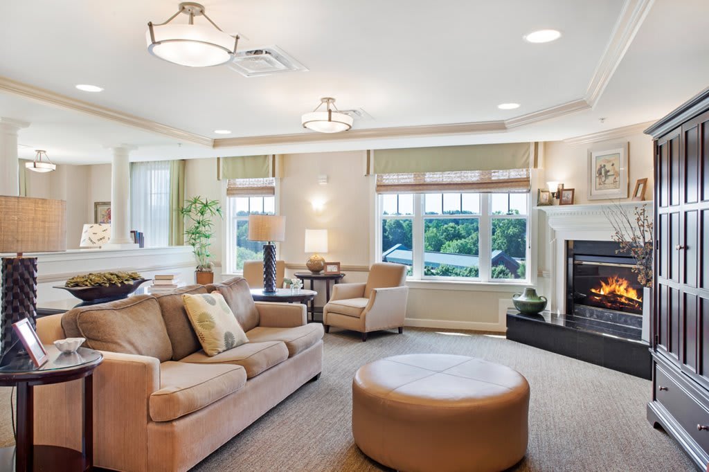 A modern and cozy living room featuring a comfortable sofa, large windows, and a fireplace.