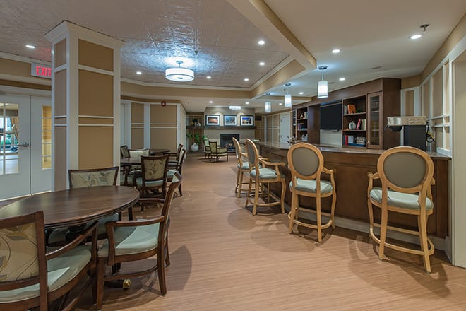 A cozy interior space featuring a bar and dining area with elegant seating and warm lighting.