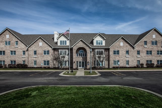 A front view of a brick residential building under a cloudy sky.