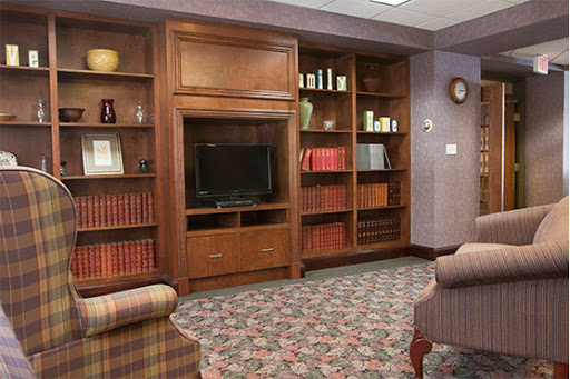 A cozy living room featuring a wooden bookshelf, a television, and comfortable seating.