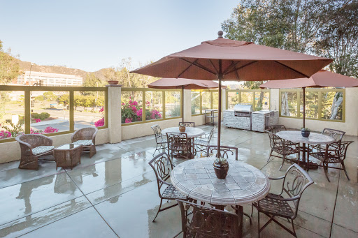 A serene outdoor patio area featuring a marble table and comfortable seating, perfect for enjoying the sunny weather.