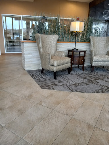 A cozy lobby area featuring stylish chairs, a small table, and a lamp, creating a welcoming atmosphere.