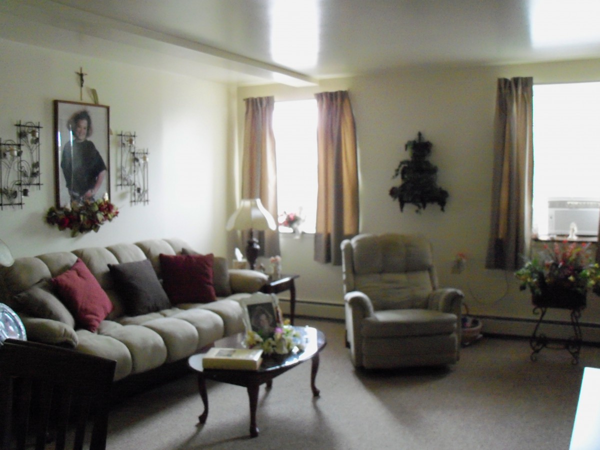 A cozy living room with a sofa, armchair, and coffee table.
