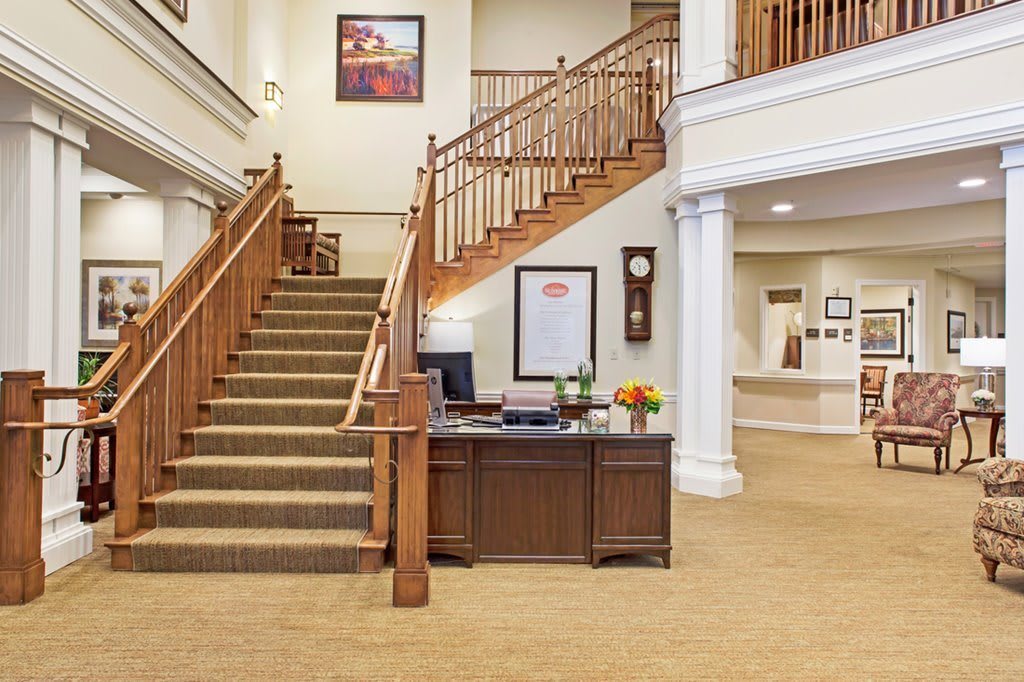 A welcoming reception area featuring a wooden staircase and office desk.