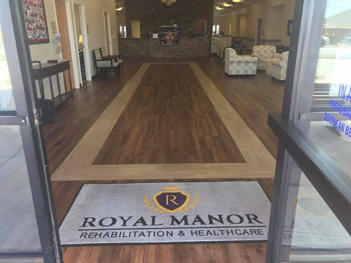 Entrance to Royal Manor Rehabilitation & Healthcare, featuring a welcoming lobby with wood flooring.
