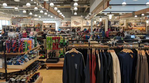 A well-organized retail store showcasing a variety of clothing and outdoor gear.