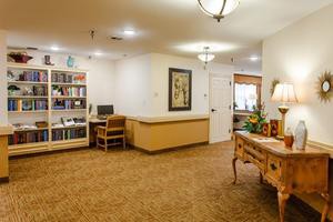 A cozy reception area with a desk, bookshelf, and warm lighting.