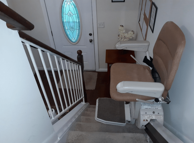 A stairlift installed beside a staircase for home accessibility.