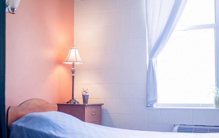 A cozy bedroom corner with a bedside lamp and curtains.