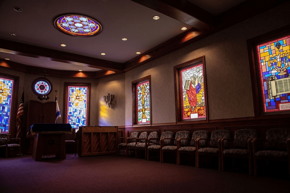A serene church interior featuring stained glass windows and seating.