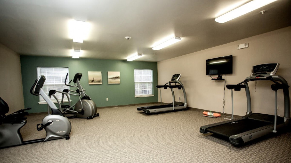 A small gym with treadmills and elliptical machines.