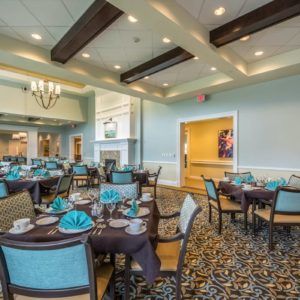 An elegantly decorated dining room with set tables and chairs, featuring a stylish interior design.