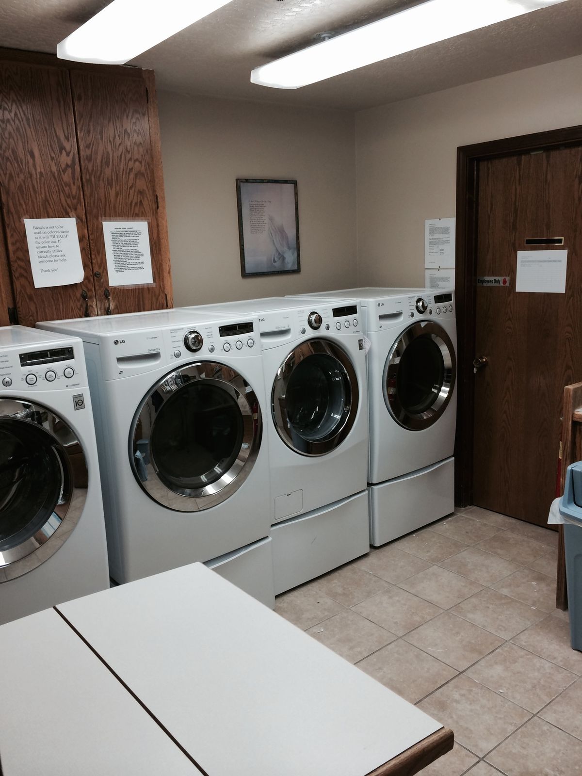 A laundry room featuring multiple washing machines in a neat row.