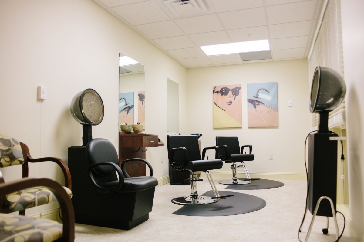 A modern salon interior with styling chairs, mirrors, and wall art.