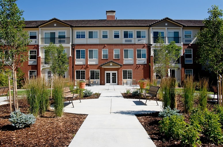 A modern residential apartment building with surrounding landscaped gardens.