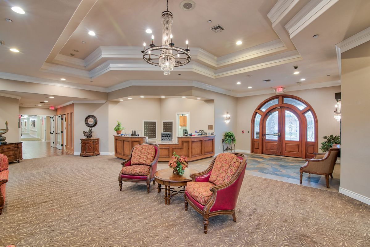 A spacious lobby with elegant furnishings and a chandelier.