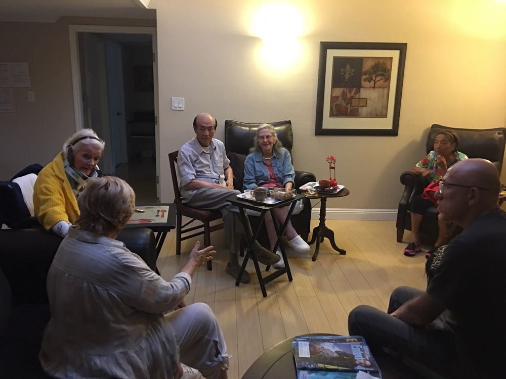 A group of people having a conversation in a cozy living room.