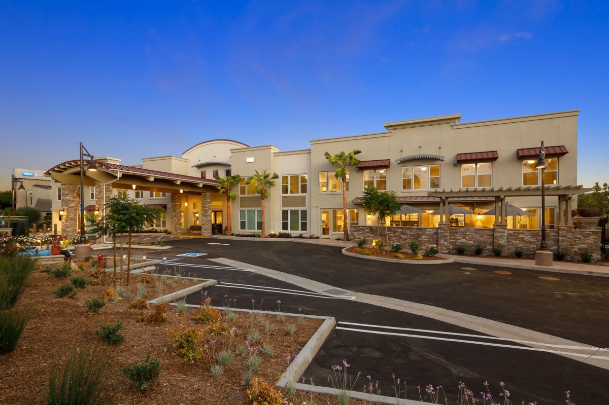 Modern building with landscaped surroundings at dusk.